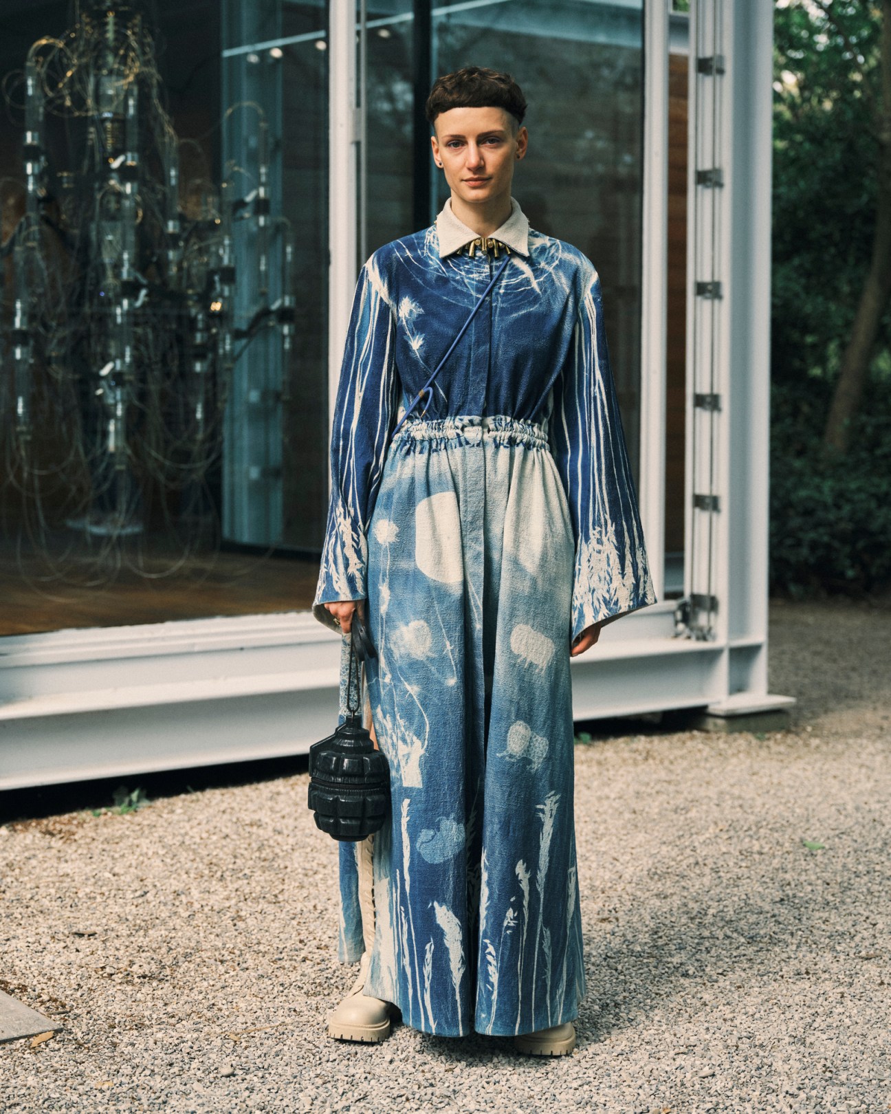 Fashion student Mariia Pavlyk stands outside wearing a blue and white patterned outfit with a white collar.