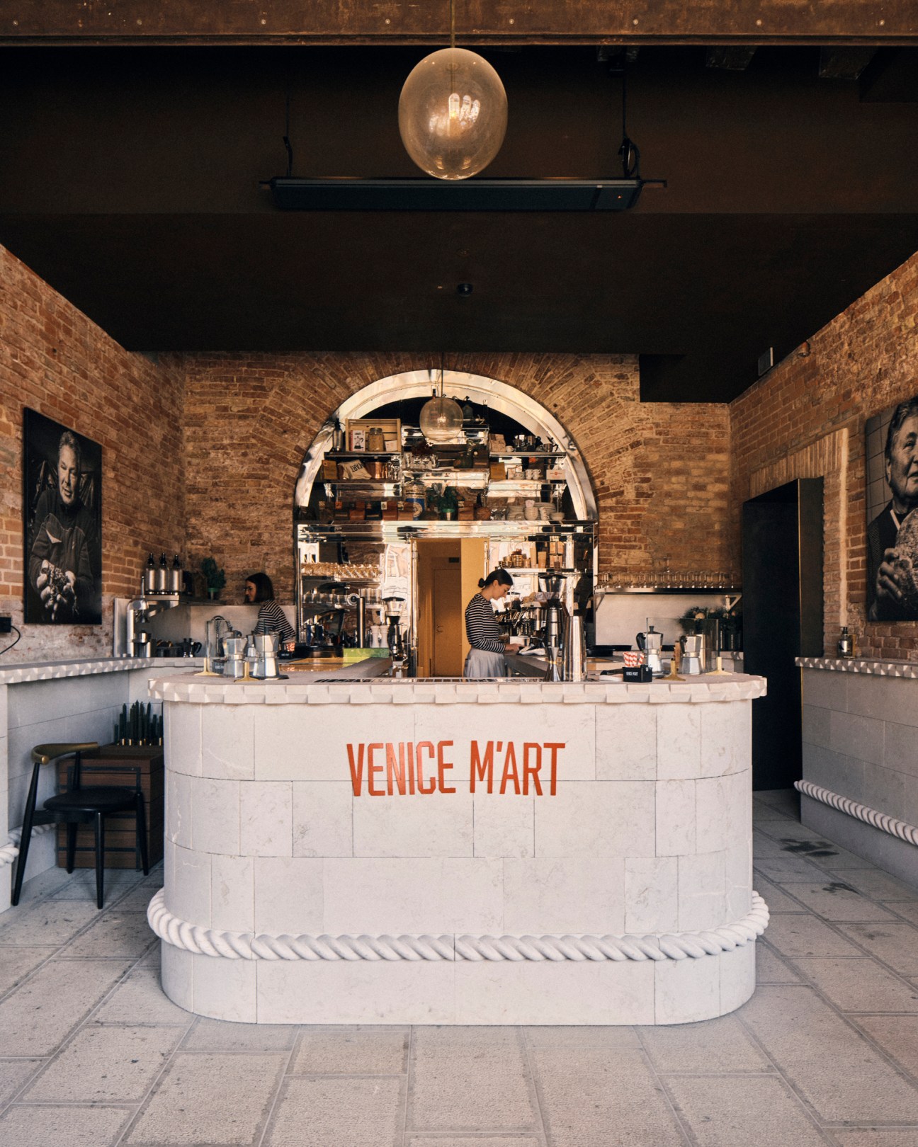 Modern coffee bar with white tiled counter displaying VENICE M'ART branding and espresso equipment