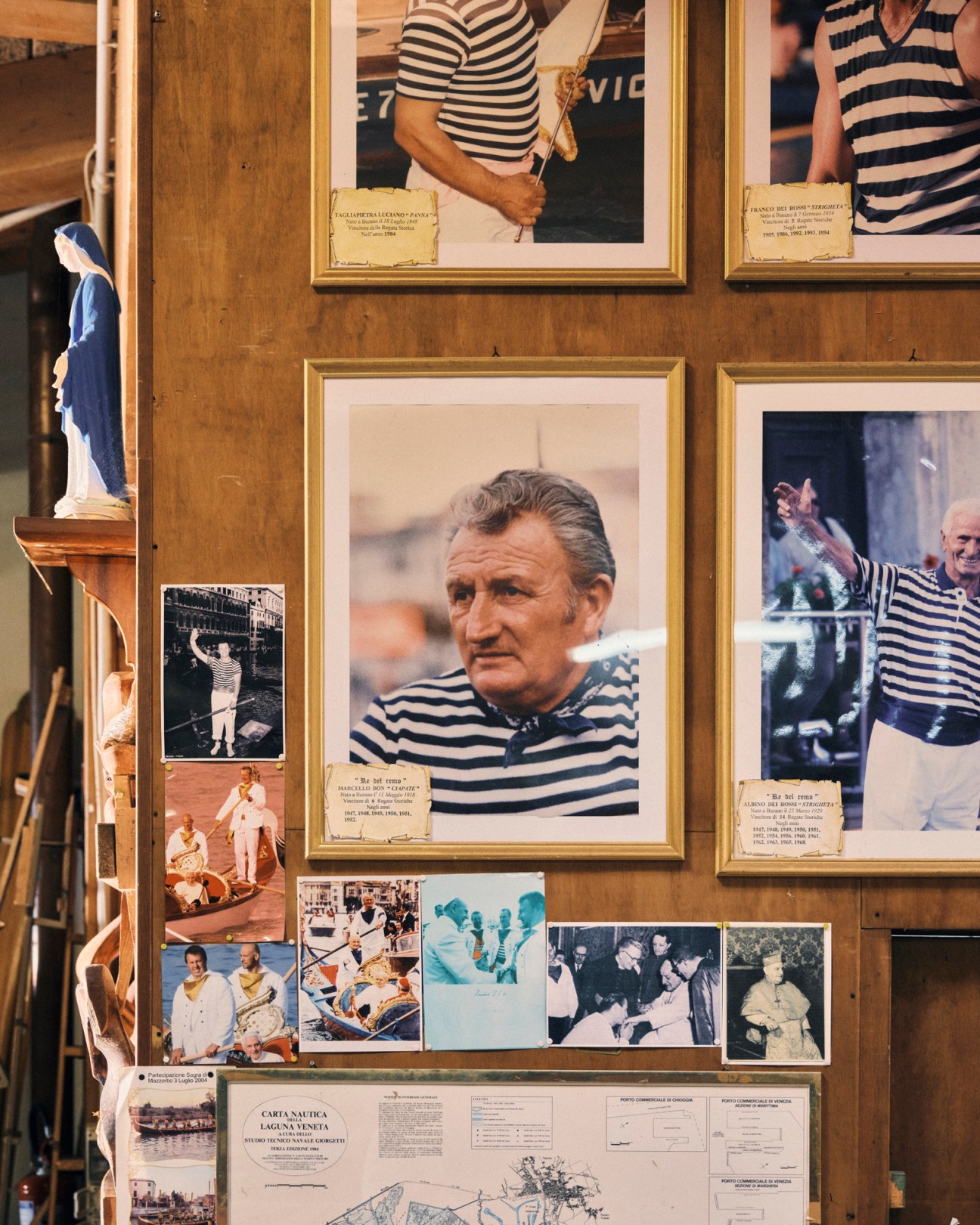 Wall display of framed photographs and memorabilia featuring portraits of people in striped shirts