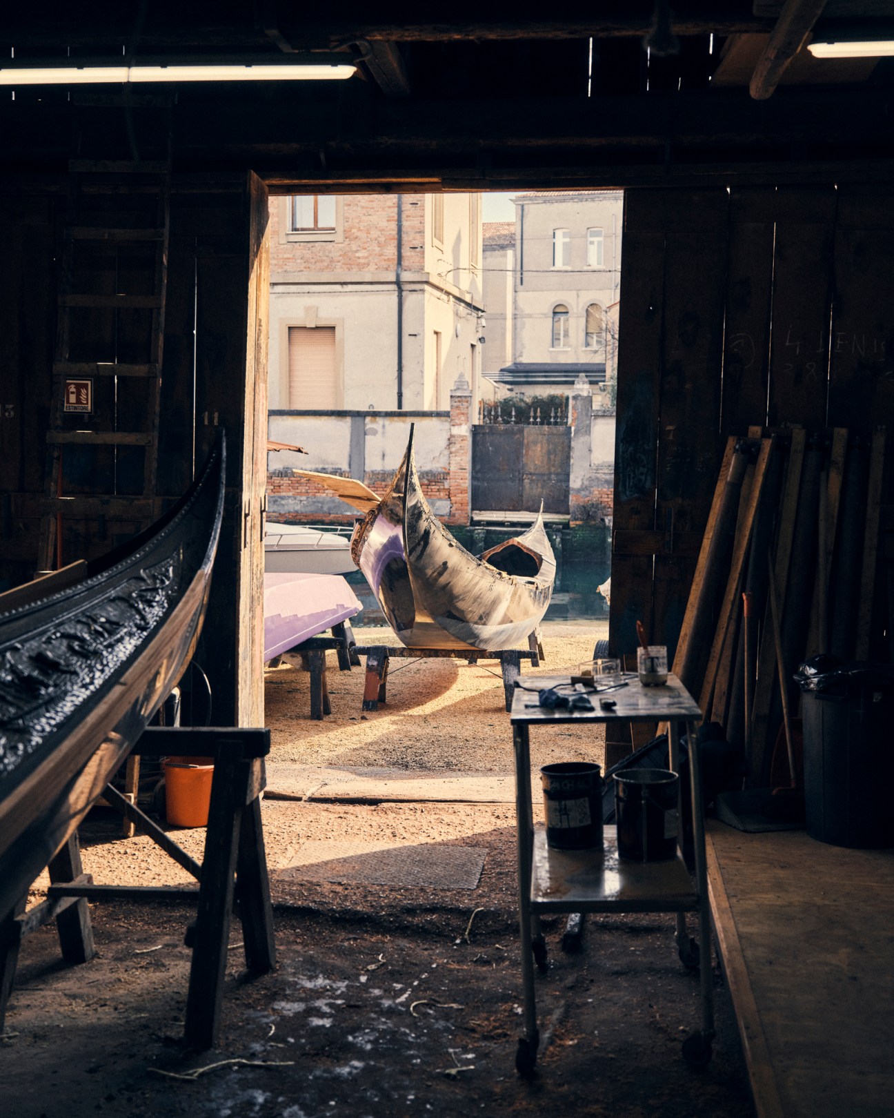 Craftsman working on traditional black gondola construction in Squero Tramontin workshop
