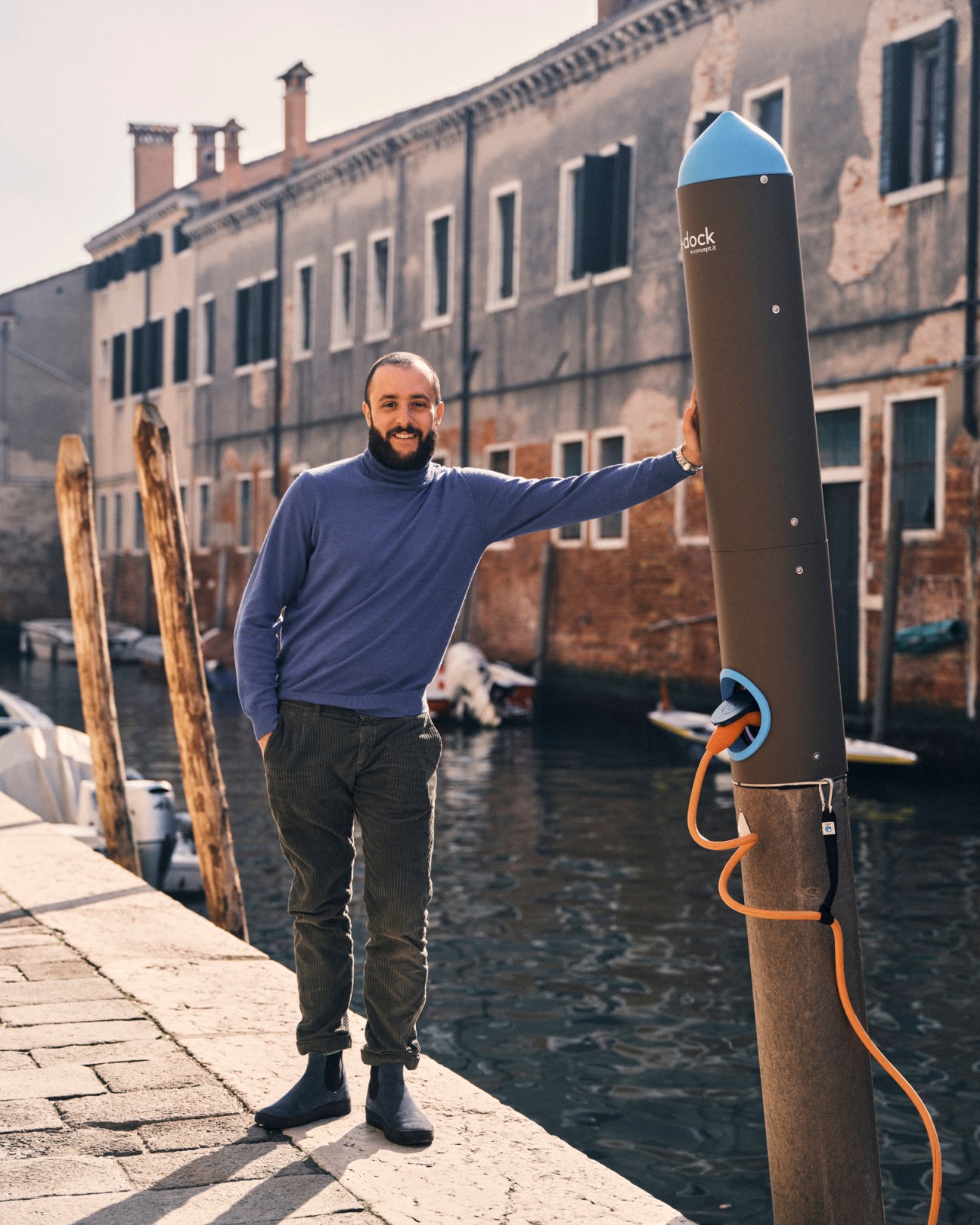 Pannoli navigating his boat through narrow Venice canal with traditional buildings on both sides