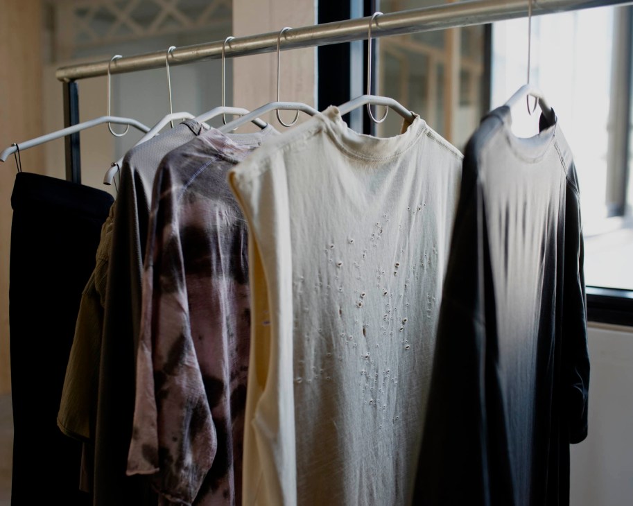 Satisfy Running performance tops hanging on rack showing strategic ventilation holes in technical fabric