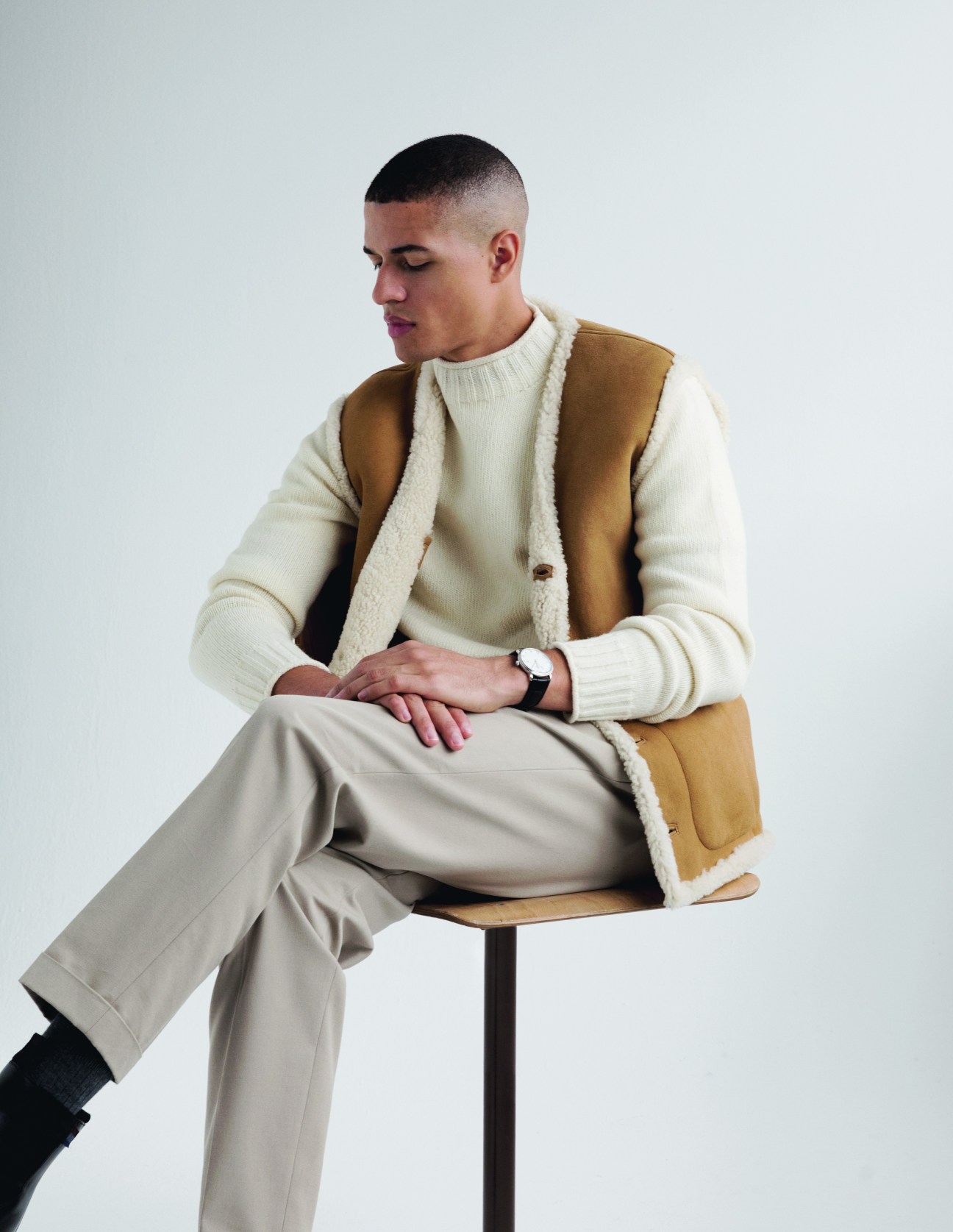 Model in casual autumn ensemble with quilted gilet over knitwear and tailored trousers
