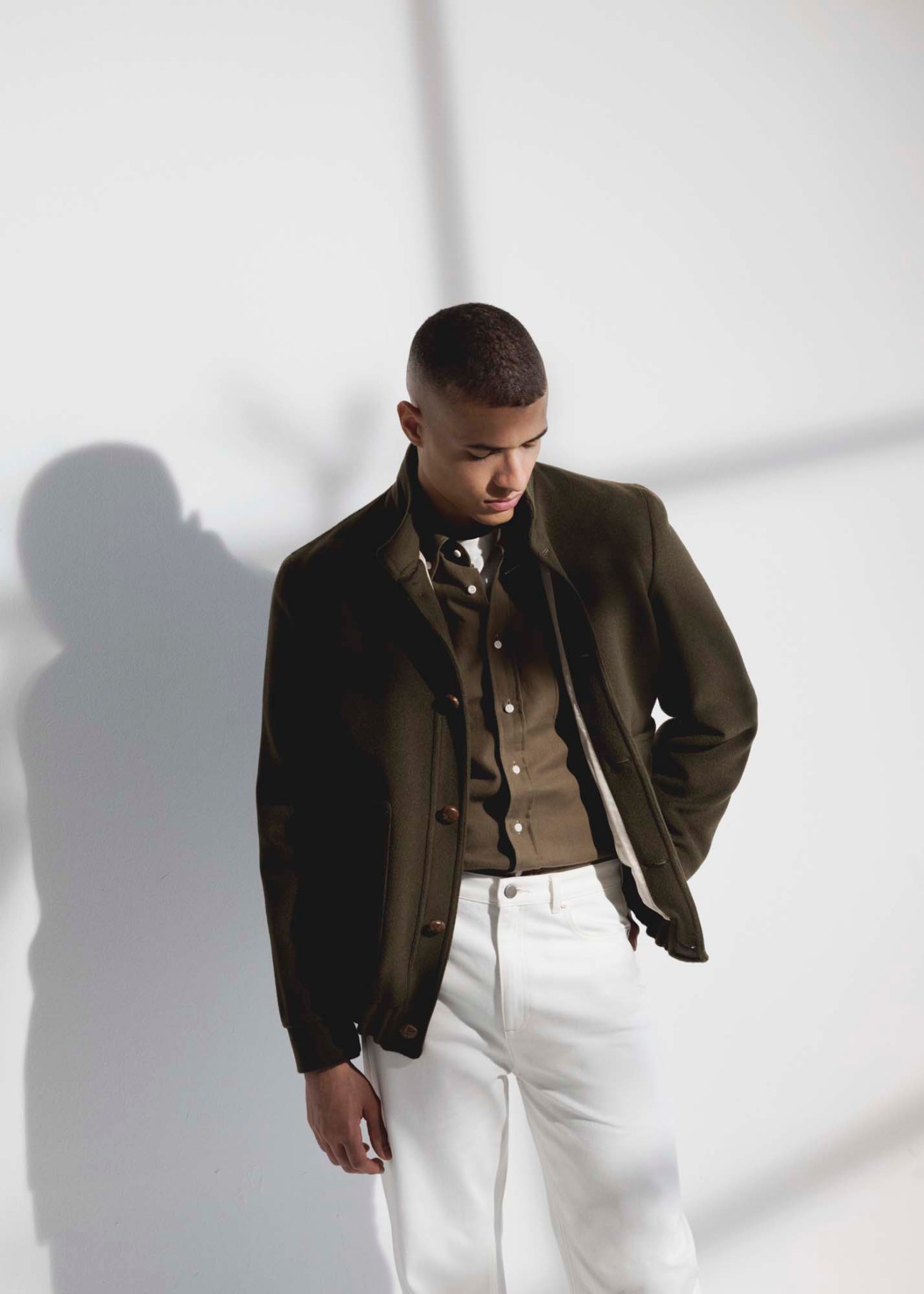 Model wearing sophisticated layered outfit with grey blazer and white shirt