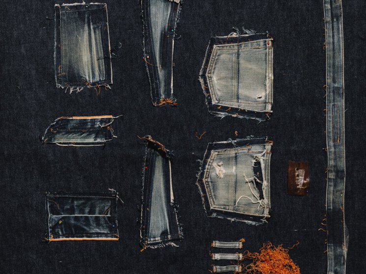 Collection of vintage denim patches and fabric samples arranged on dark background