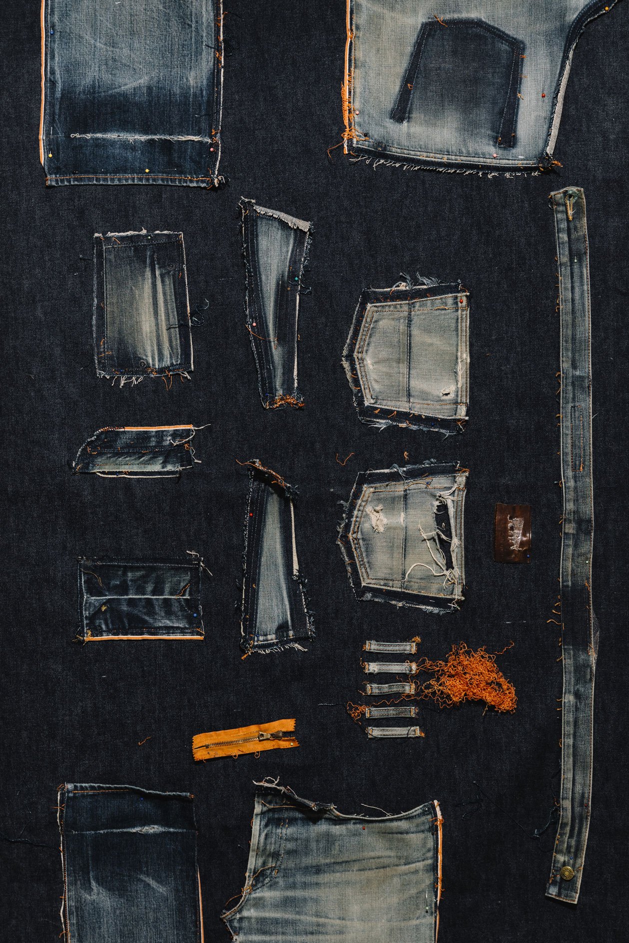 Collection of vintage denim patches and fabric samples arranged on dark background