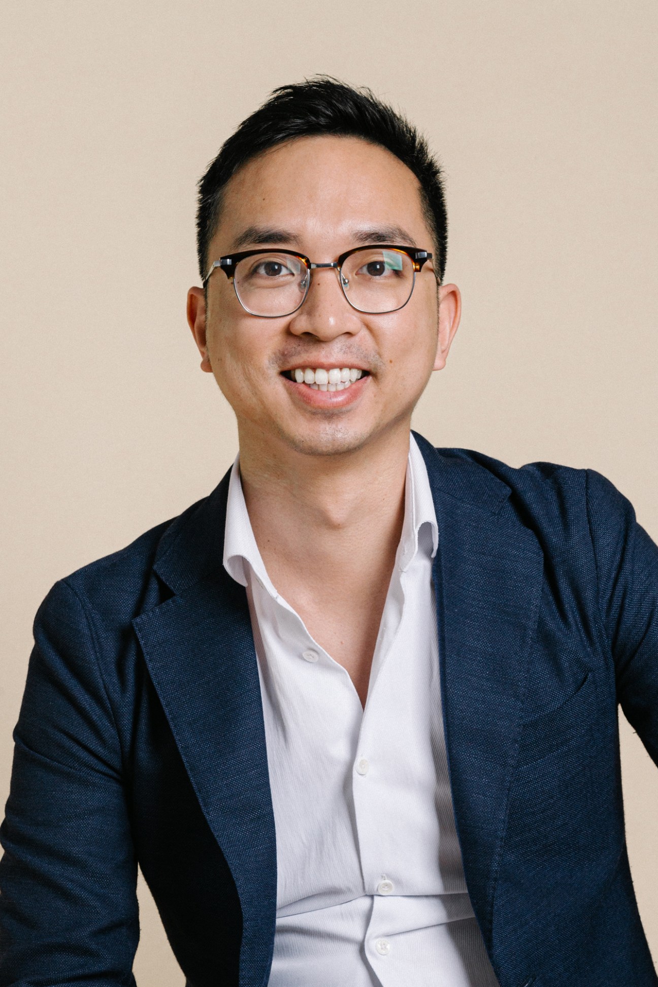 Hao Tran, co-founder of Vietcetera, smiling in a dark blazer and white shirt against a neutral background.