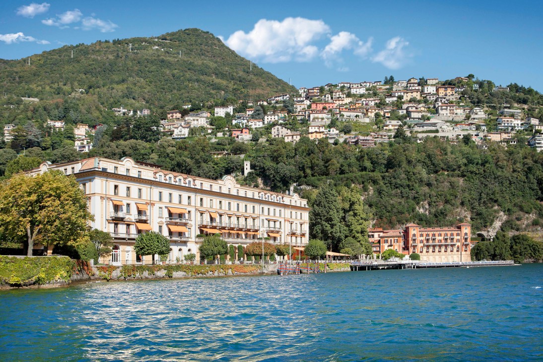 Villa d'Este hotel viewed from Lake Como with historic buildings, terraced gardens and mountain backdrop