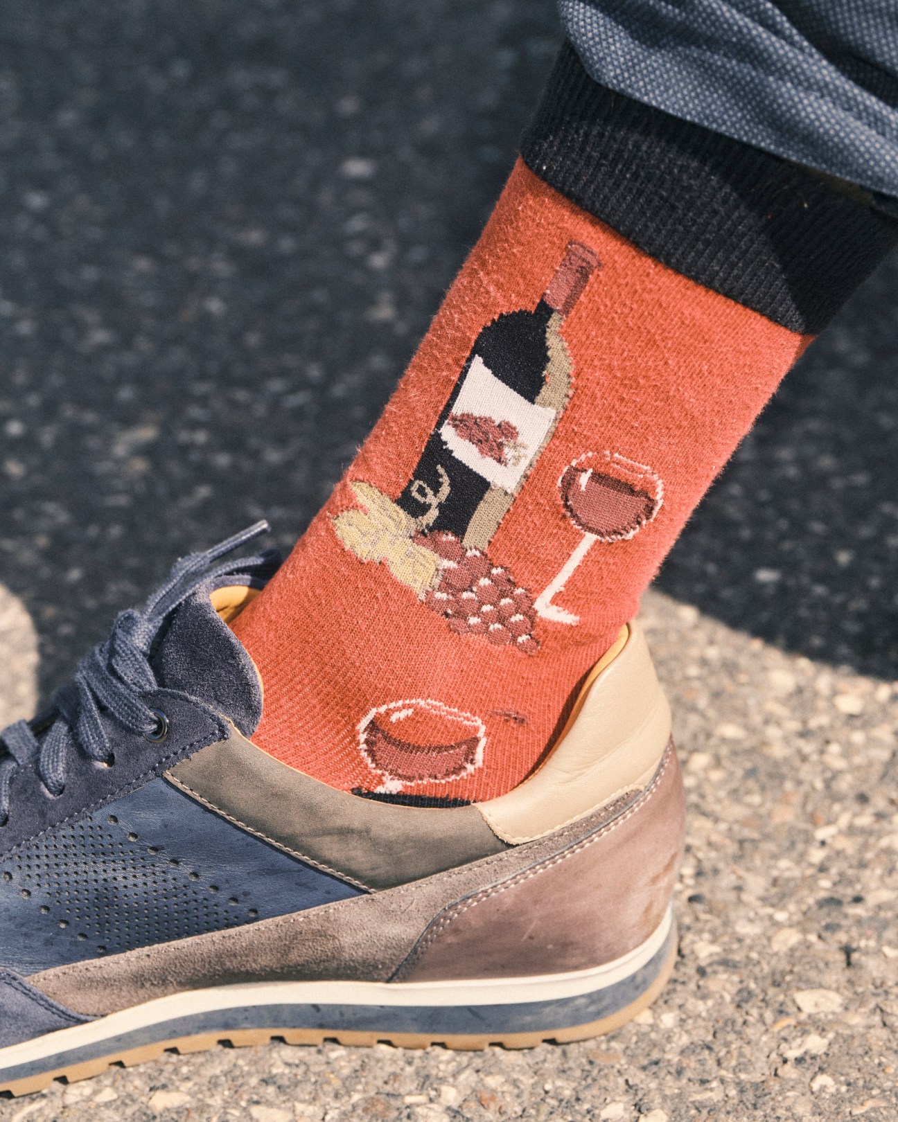 Orange socks with wine bottle and glass pattern worn with brown and navy sneakers