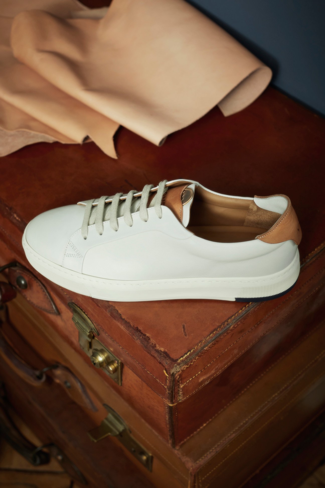 Close-up of white sneaker showing wooden shoe trees inserted inside