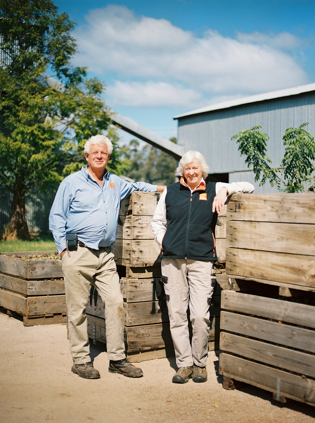 Michael Burston and Carol Kunert of King Valley Walnuts standing by wooden crates at their farm
