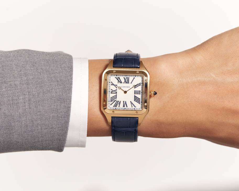 Cartier Santos-Dumont watch with square rose gold case and blue leather strap on wrist