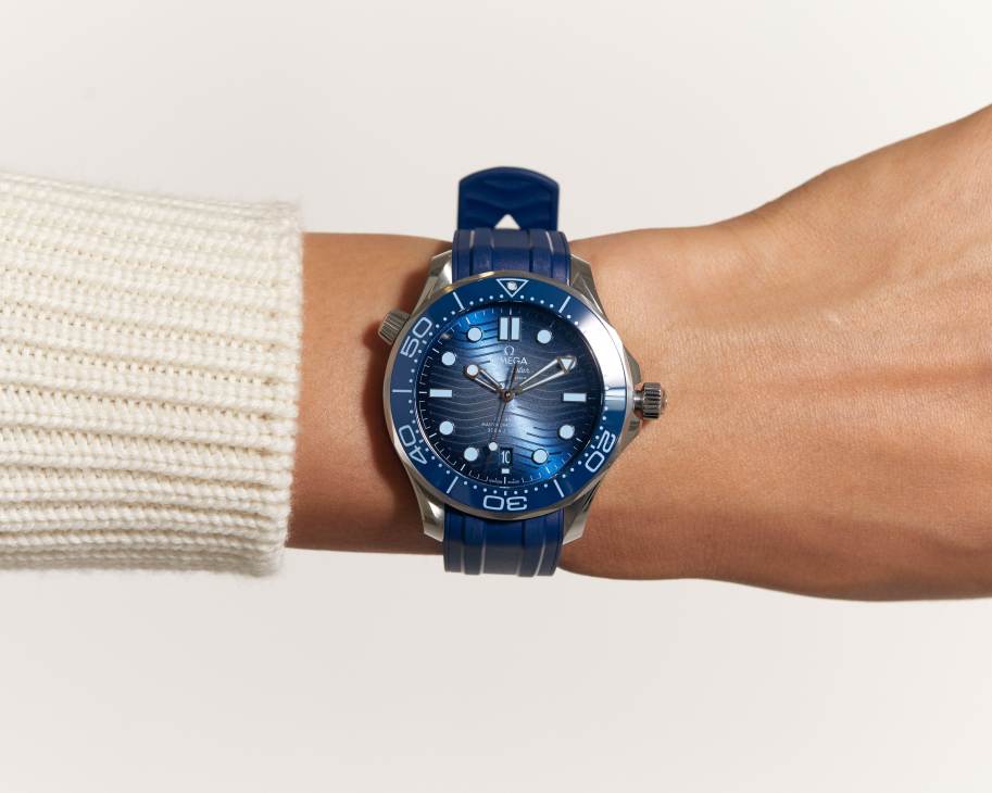 Omega Seamaster Diver 300M watch with blue dial and blue rubber strap worn on wrist