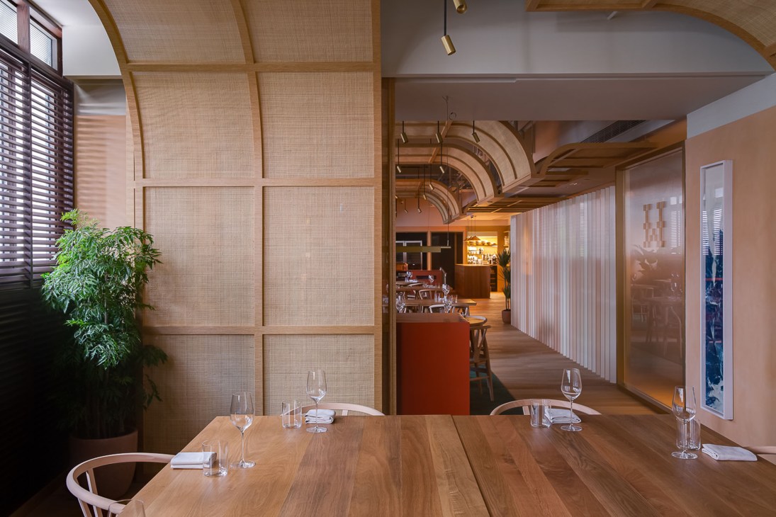 Interior of Whey restaurant showing Nordic-inspired design with oak furniture and rattan