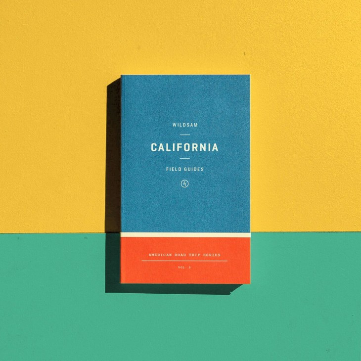 Wildsam California Field Guides travel handbook with blue cover and orange spine against yellow and green background.