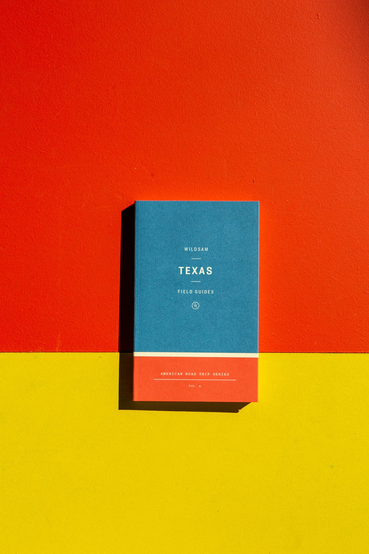 Wildsam Texas Field Guides book cover with blue and coral sections against red and yellow background.