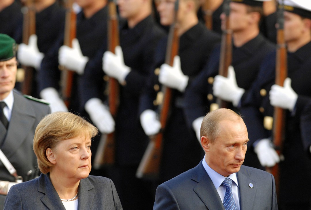 Angela Merkel and Vladimir Putin standing together at formal diplomatic meeting in 2007