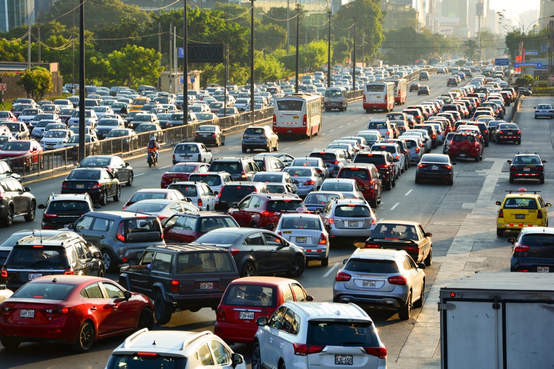 Heavy traffic congestion on a multi-lane highway in Lima showing dense rows of cars and buses during rush hour