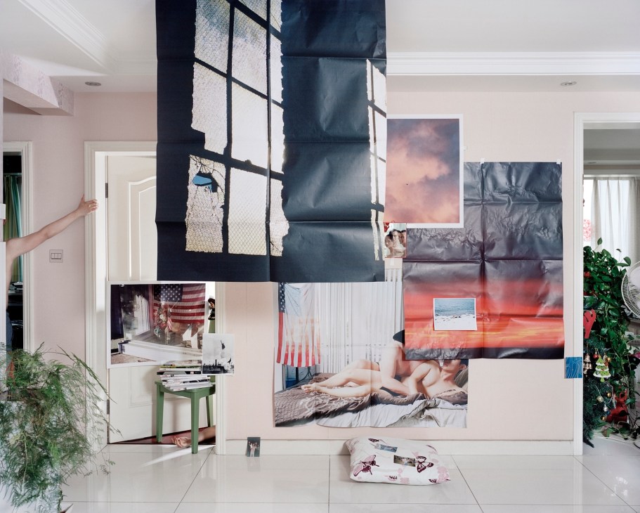 Large photographic prints and artworks arranged in a collage-like installation in a white interior space