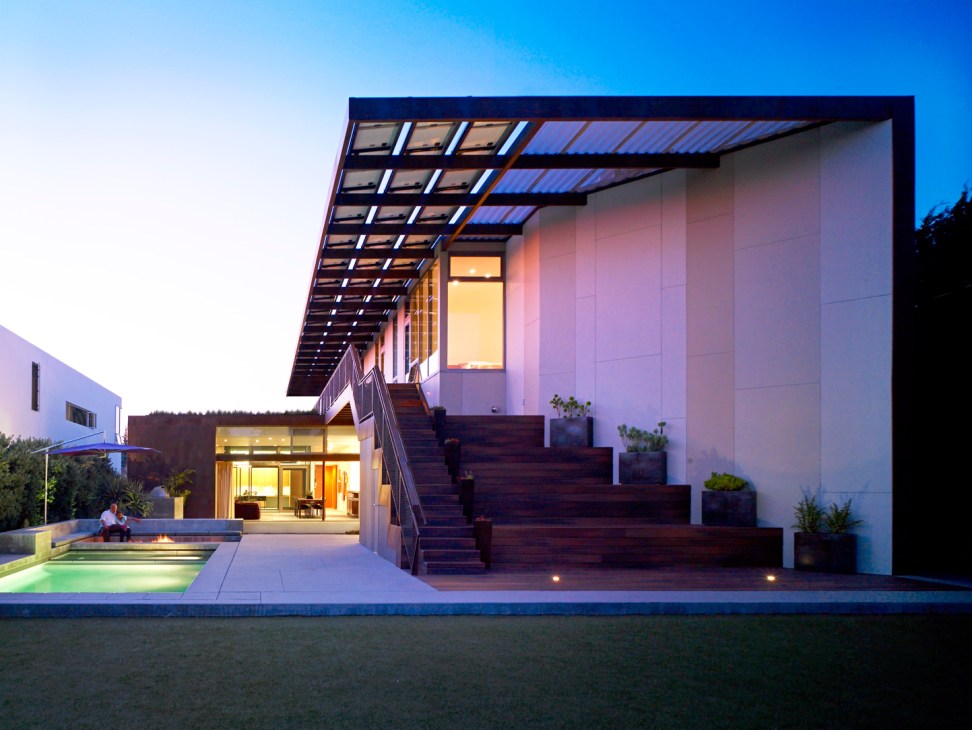 Modern white house with angular architecture and large windows at dusk