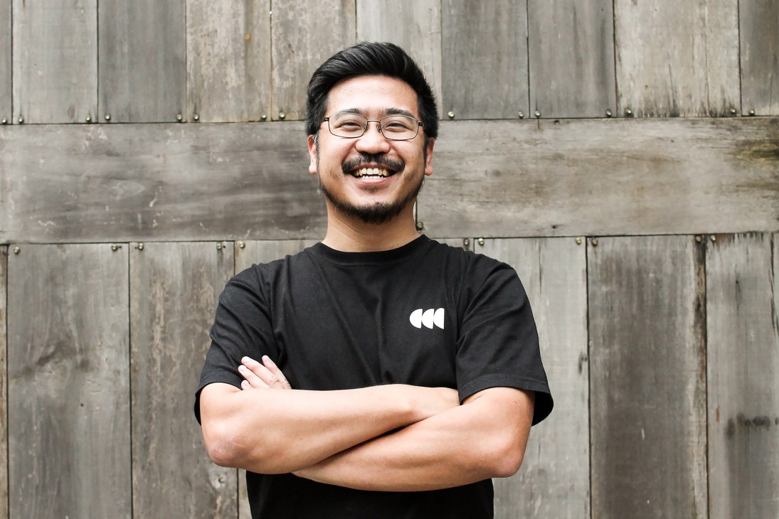 Yoshua Tanu, CEO and co-founder of Jago Coffee, smiling with arms crossed wearing glasses and black t-shirt