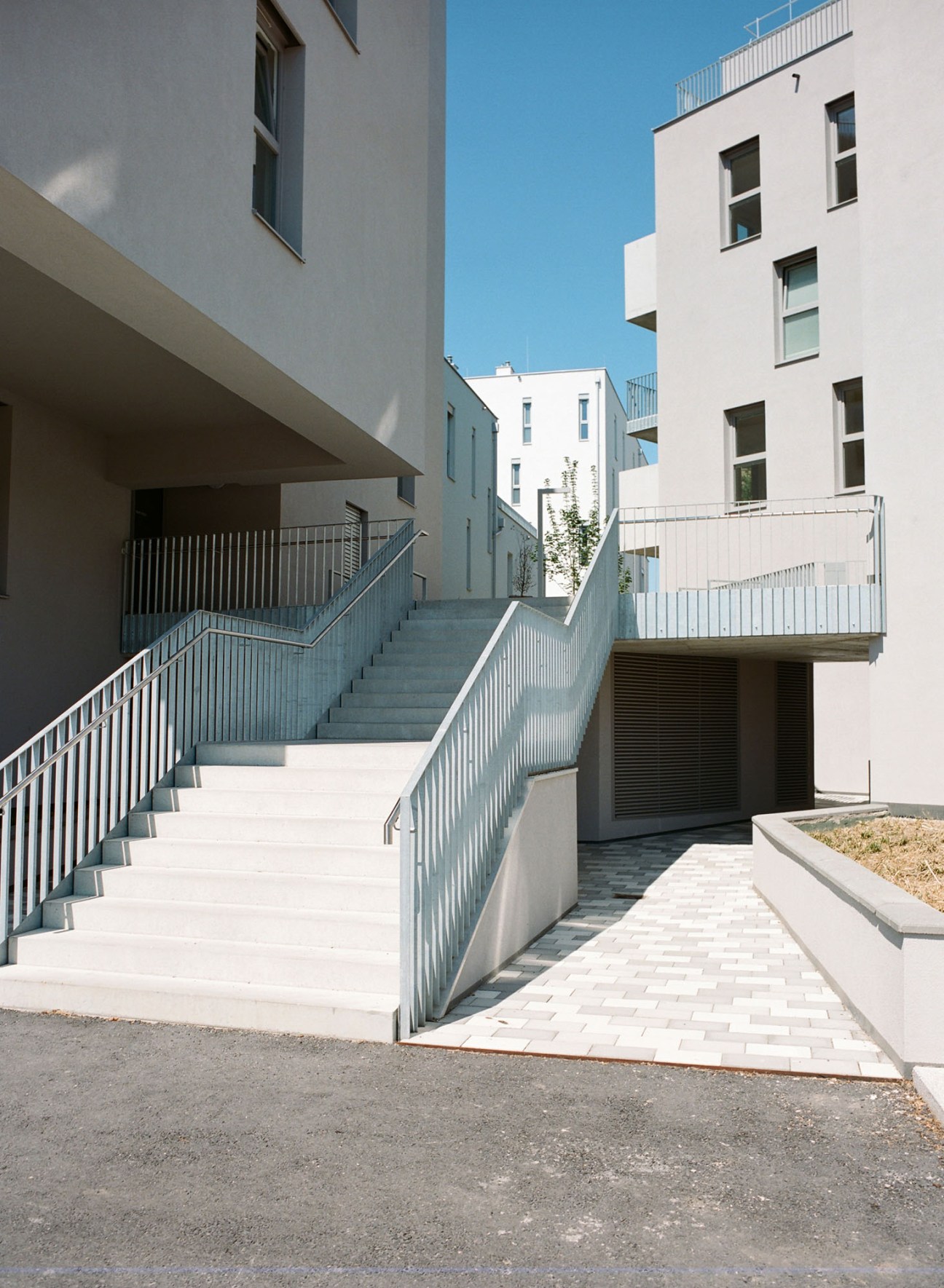 Stone steps with metal railings leading through the Wildgarten housing complex