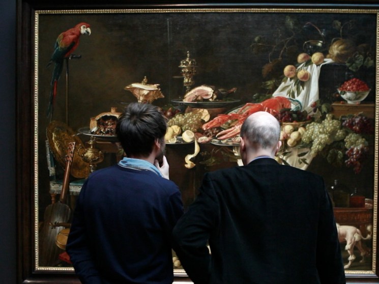 People observing a painting.