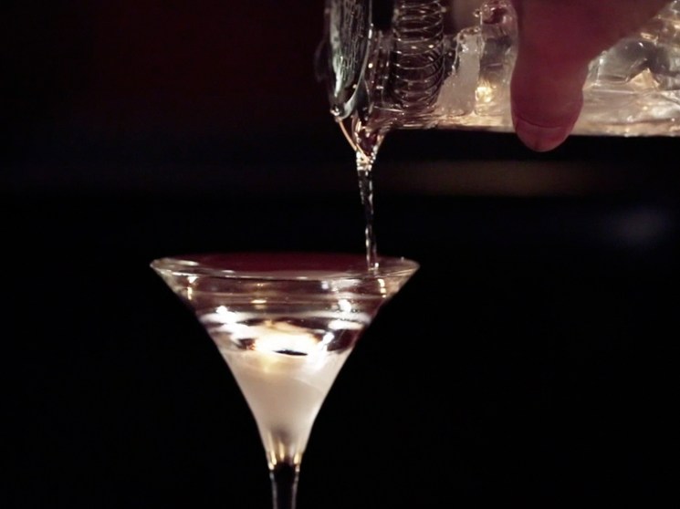 pouring drink into a cocktail glass