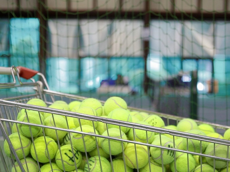 A cart filled with tennis balls.