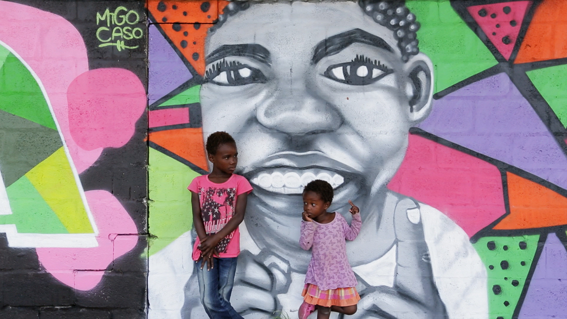 Children in front of a painted wall.