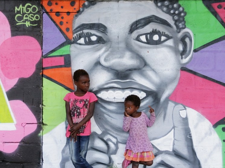 Children in front of a painted wall.