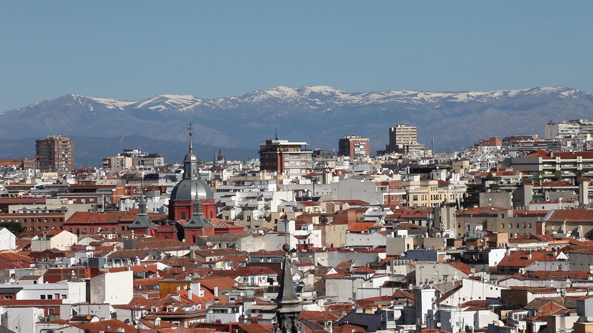 An overview of Madrid with mountains in the background.