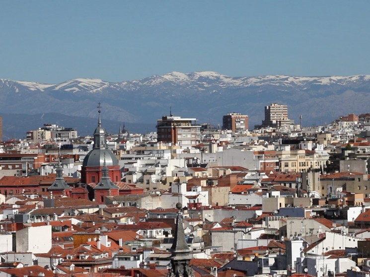An overview of Madrid with mountains in the background.