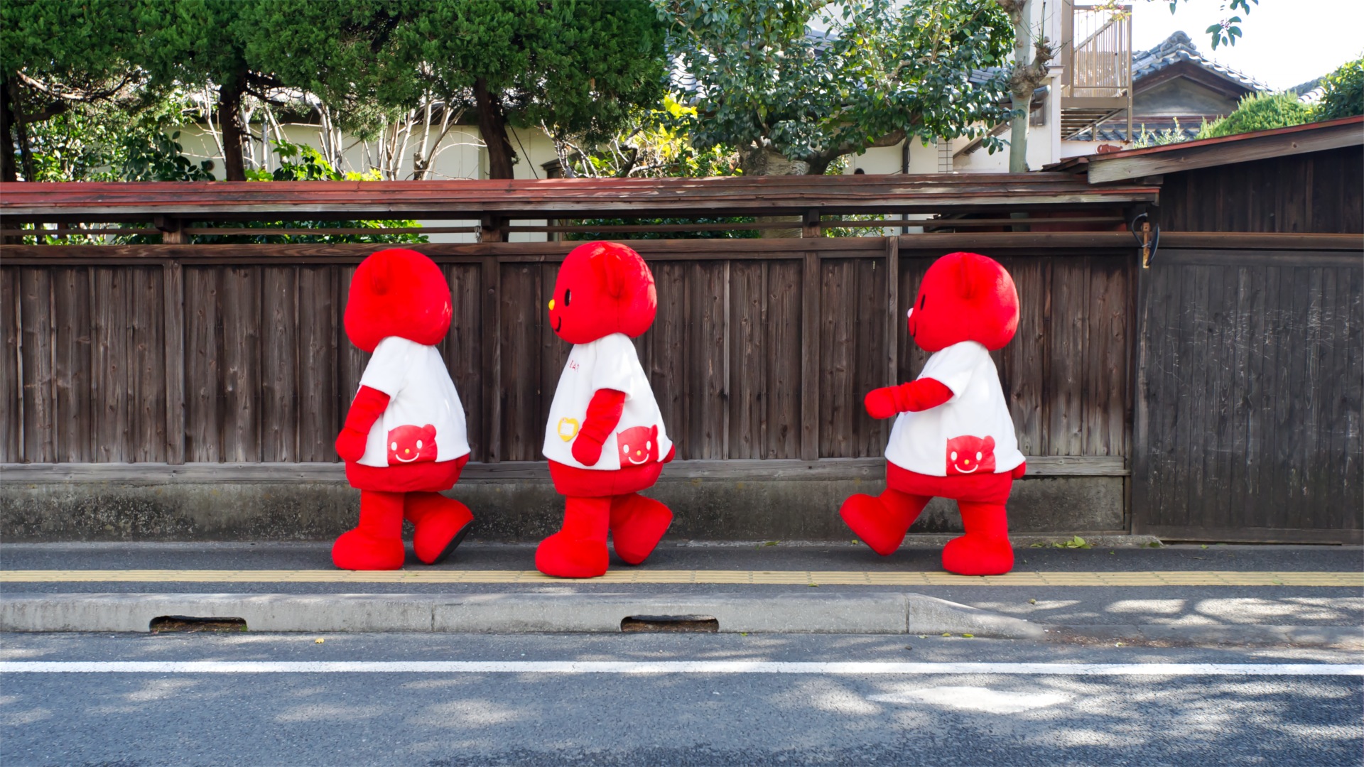 Japanese mascots walking in the street.