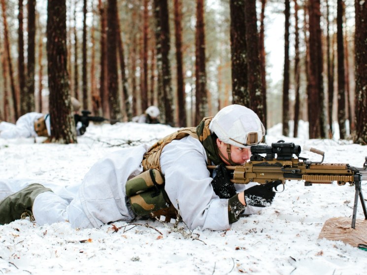 A soldier training in snowy woods.