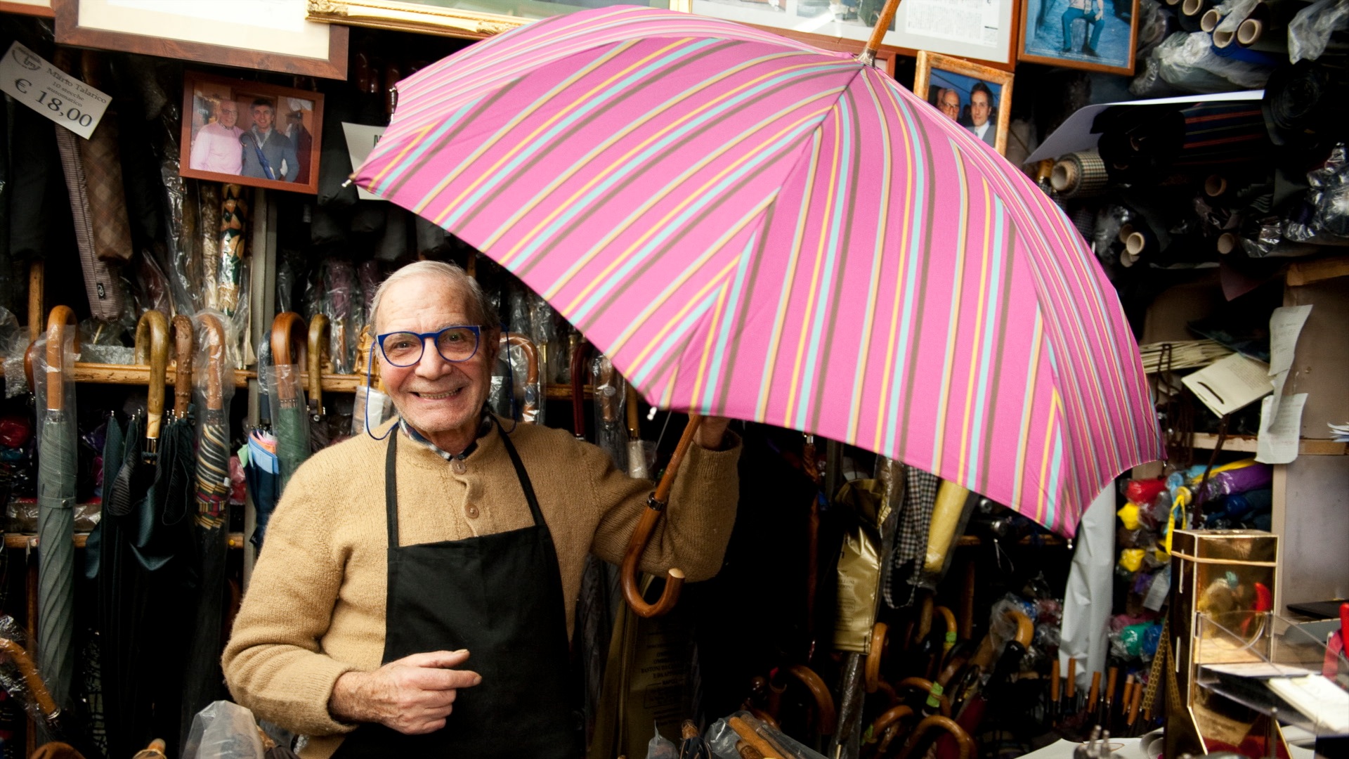 A man with an umbrella in a shop.