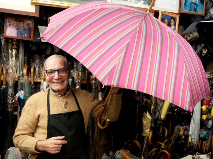 A man with an umbrella in a shop.