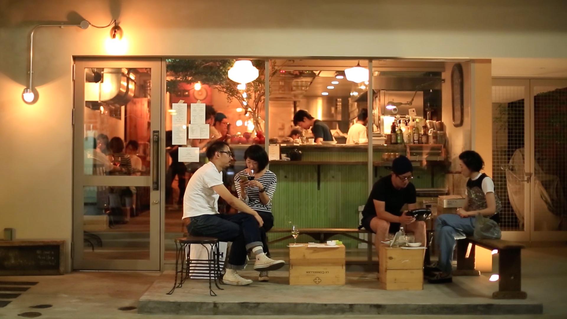 People sitting in front of a bar in Tokyo.
