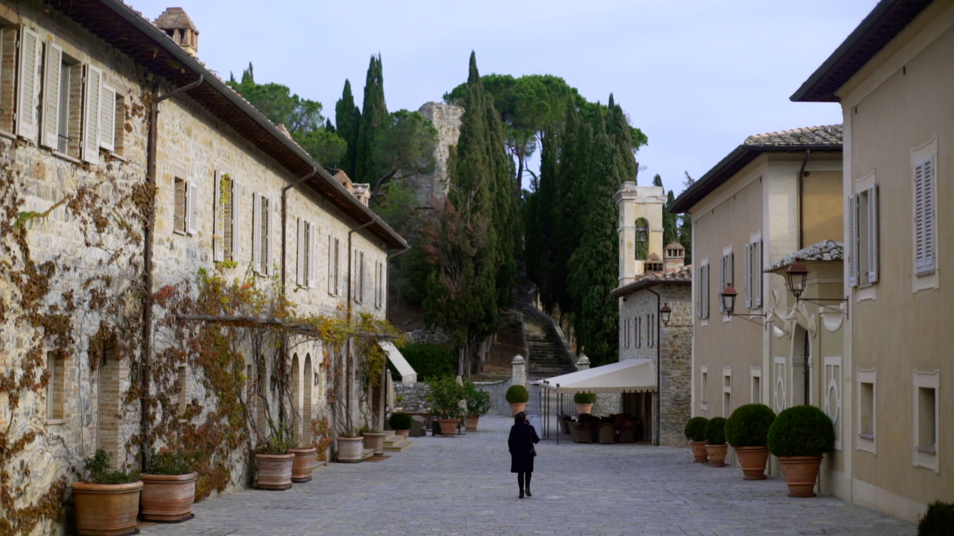 A woman walking through Castiglione del Bosco.