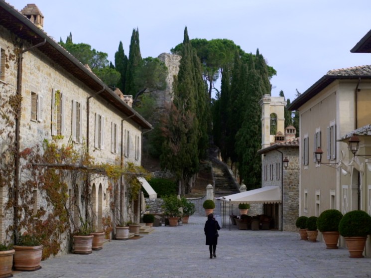 A woman walking through Castiglione del Bosco.
