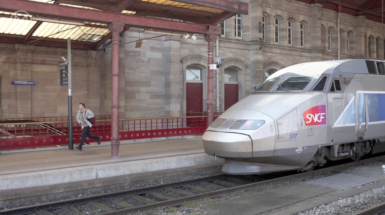 man running and train at station