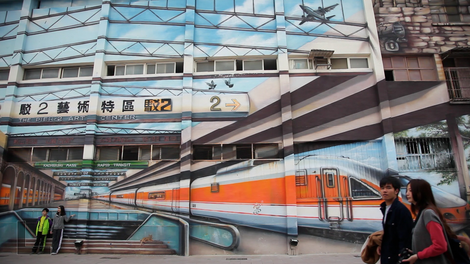 people next to a building with train graffiti