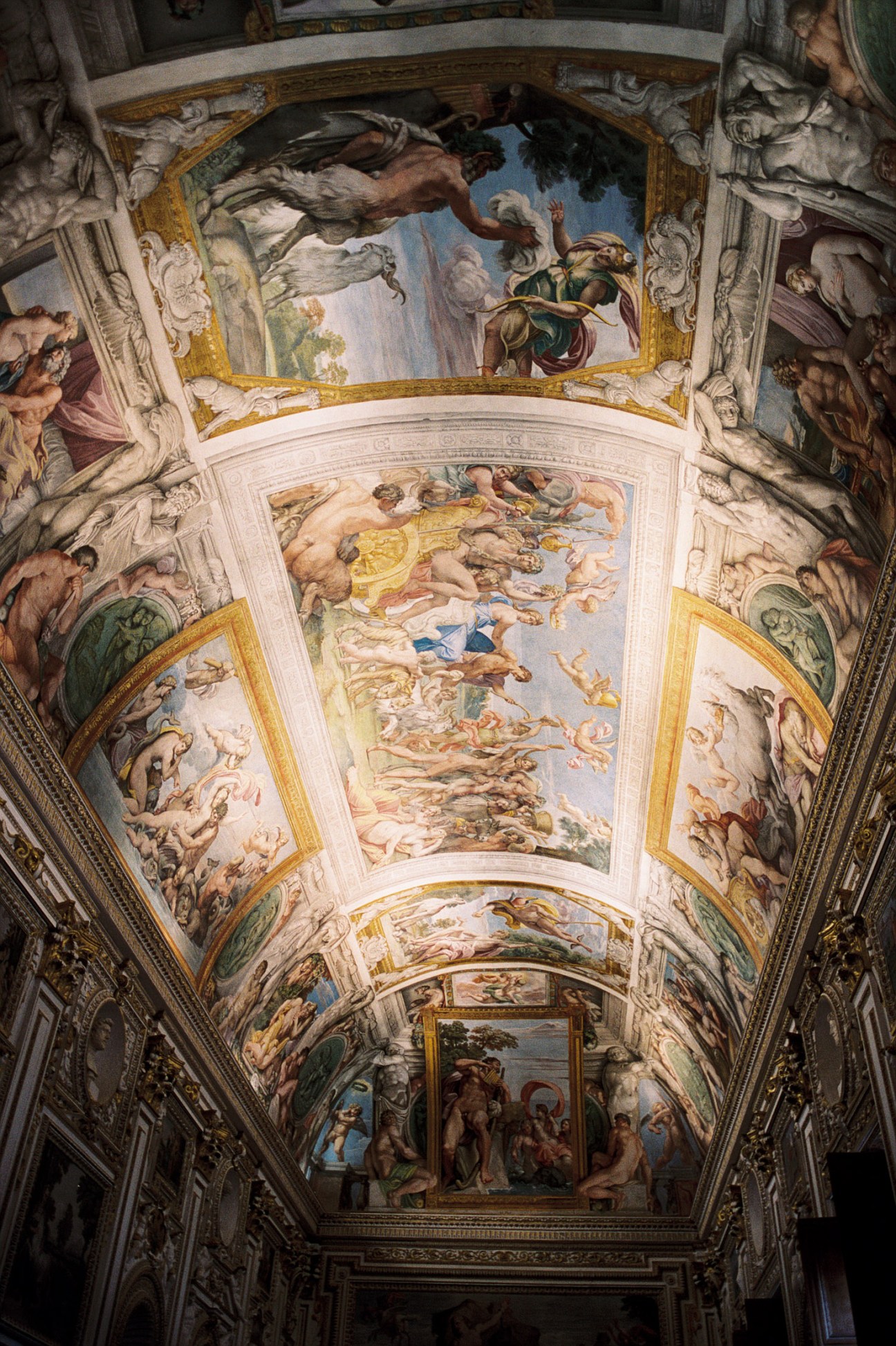 Ornate Renaissance ceiling frescoes with classical figures and gold-leaf framing in the Galleria dei Carracci.