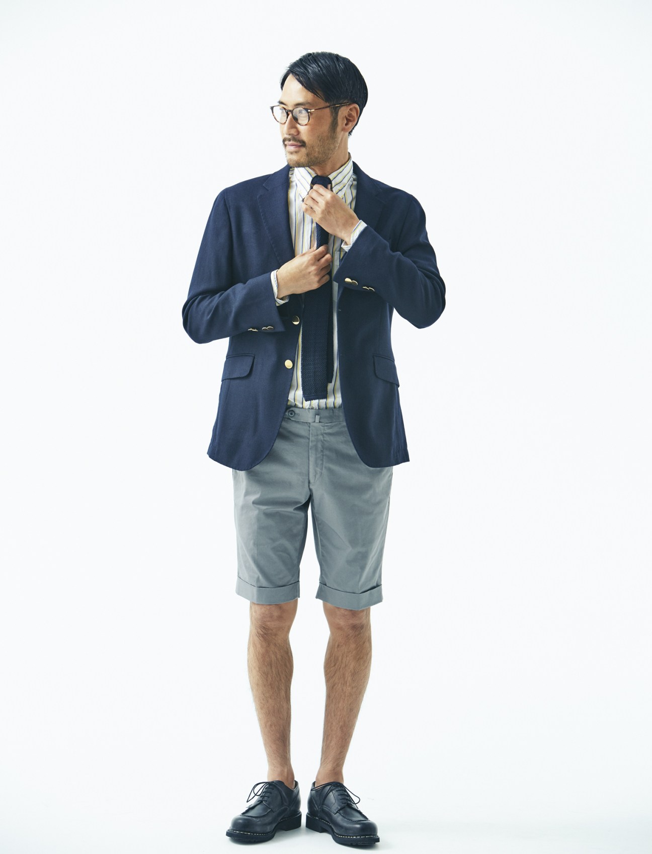 Man wearing navy Hackett London jacket, Drake's shirt and tie, Tomorrowland shorts, Paraboot shoes and Eyevan 7285 glasses.