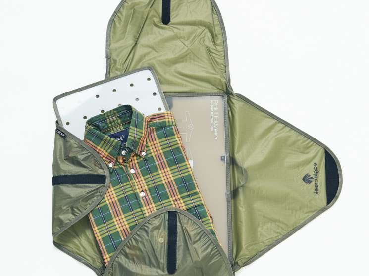 Open green garment holder by Eagle Creek displaying a checkered shirt by Drake's inside.