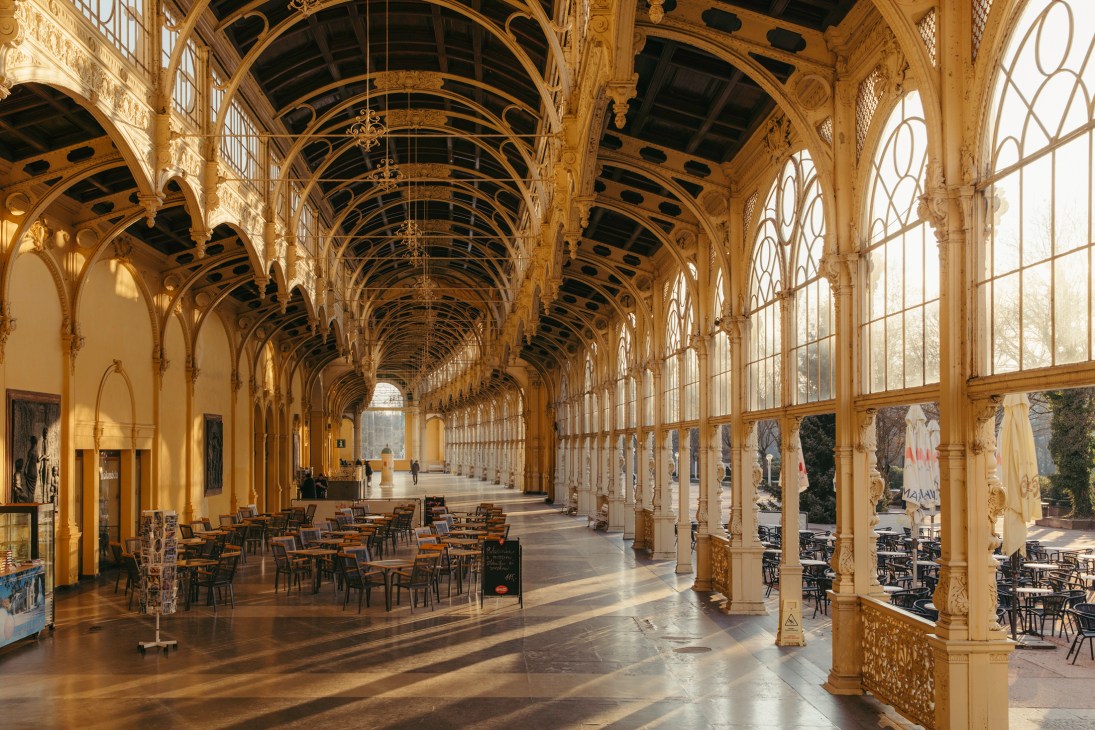 The Main Spa Colonnade interior with ornate arched ceiling, columns, and dining tables