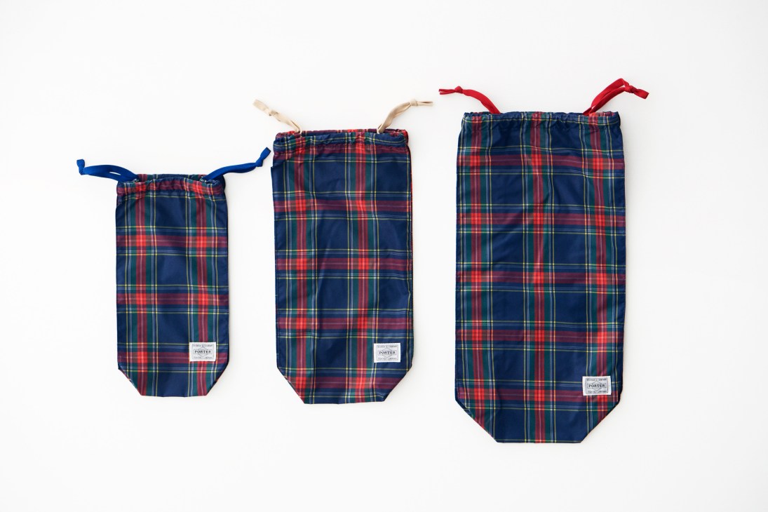Three tartan plaid pouches with drawstring handles by Porter in navy, red and green.
