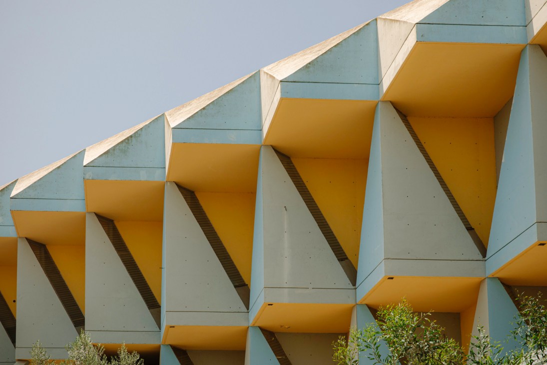 Colorful brutalist architecture with yellow and blue geometric concrete forms at the Technion campus.