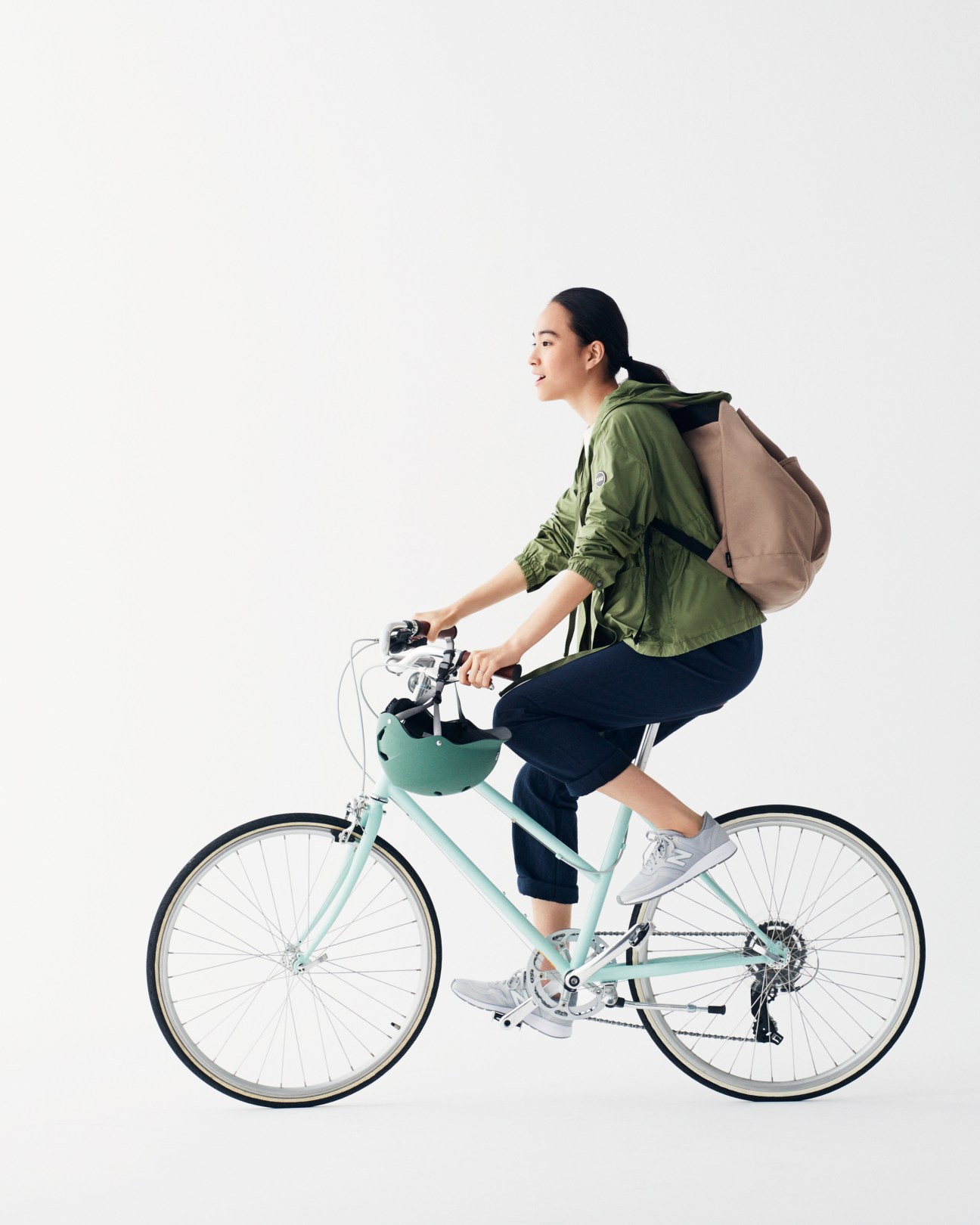 Woman riding a light blue Tokyobike wearing a green Colmar jacket and backpack