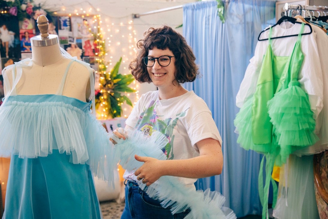 Shahar Avnet working with tulle fabric among dress designs in her studio.